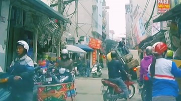 Tự dùng gầu leo lên xe tải, máy xúc ‘ngã nhào’ giữa đường đông người