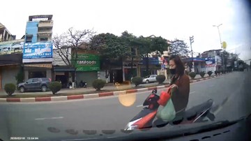 Người phụ nữ chạy xe máy ngược chiều bằng 1 tay bị ô tô đâm trúng