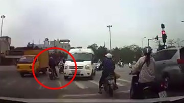 Người phụ nữ dừng xe máy giữa ngã tư chờ đèn đỏ