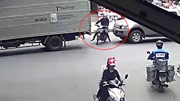 Xe máy cố sang đường bị ô tô đâm trúng, ép kẹt vào đuôi xe tải