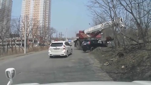 Xe cẩu mất phanh kéo lê xế hộp lên sườn dốc, dính chặt vào hàng cây