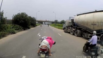 Người phụ nữ quay xe máy giữa đại lộ nhặt đồ bất chấp nguy hiểm
