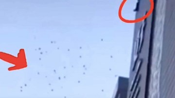 Bế tắc, một nam giới leo lên nóc nhà ném hàng trăm triệu xuống đất