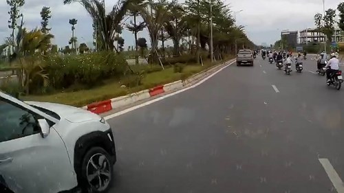 Cố vượt giữa làn thu hẹp và xe tải, ô tô con suýt leo lên dải phân cách
