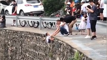 Cầm tay trẻ 3 tuổi thả ngoài vách đá dựng đứng để…chụp ảnh