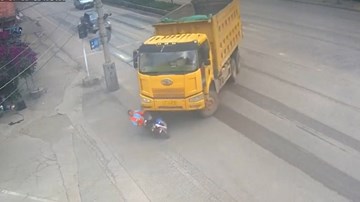 Bị xe tải ‘nuốt chửng’, người phụ nữ đi xe điện thoát chết kỳ diệu