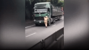 CSGT bị ép chạy lùi hàng chục mét khi dùng tay cản xe đầu kéo vi phạm