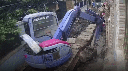 Máy xúc làm bức tường đổ sập, hàng chục người hốt hoảng lao vào đống đổ nát