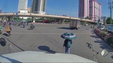 Nữ sinh thong thả đi bộ trước đầu xe container dù tài xế liên tục bấm còi