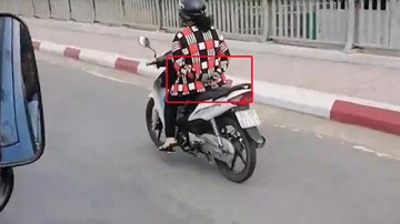 Bỏ cả 2 tay khi chạy xe máy qua cầu, người phụ nữ khiến cả phố chú ý