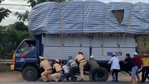 CSGT cùng người dân hợp sức giữ thăng bằng, giải cứu xe quá khổ suýt bị lật