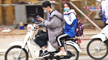 Học sinh đầu không mũ BH, tay lướt điện thoại phóng xe vun vút đến trường