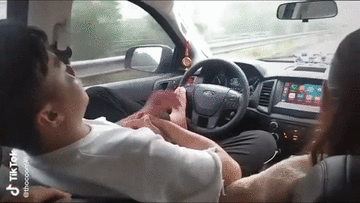Tài xế dùng chân điều khiển ô tô, tay thì âu yếm bạn gái ngồi bên cạnh