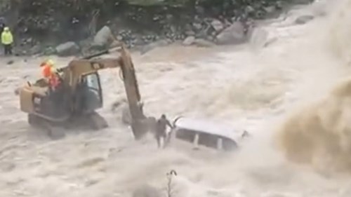 Máy xúc giải cứu tài xế ô tô bị mắc kẹt giữa dòng sông chảy xiết