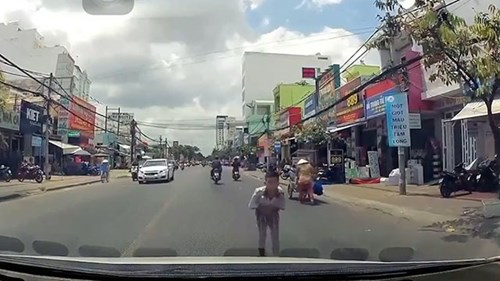 Cậu bé khoanh tay, cúi đầu cảm ơn khi được tài xế dừng xe nhường đường