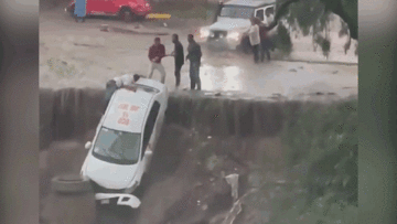 Taxi bị nước lũ cuốn kẹt vào vách đá, nhiều người mạo hiểm giải cứu tài xế