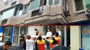 Người dân hợp sức căng rèm hứng cậu bé rơi khỏi cửa sổ chung cư