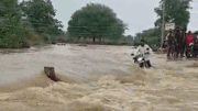 Khoảnh khắc sinh tử của người đàn ông đi xe máy cố băng qua dòng nước lũ