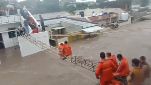 Giải cứu trẻ em vùng lũ nhờ khung sắt bắc qua các mái nhà ở Ấn Độ