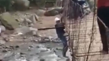 Cố đi xe máy qua cầu treo cũ kỹ, người đàn ông lơ lửng giữa cầu