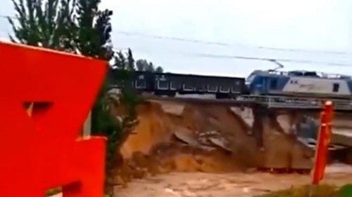 Nước lũ cuốn trôi chân cầu khiến đoàn tàu treo lơ lửng trên đường ray
