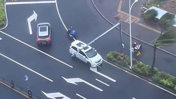 Hai ô tô che chắn và ‘hộ tống’ người đi xe máy bị gió bão Kompasu thổi ngã