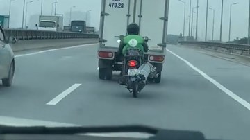 Thanh niên chạy xe máy chở hành cồng kềnh trên đường vành đai 3