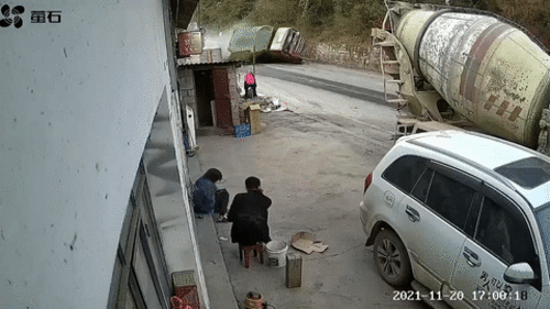 Khoảnh khắc hai người ngồi trước cửa nhà tránh kịp xe tải chở cát bị lật