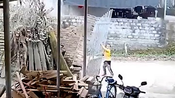 Bé gái bị cả mảng tường và cánh cổng sắt đè sập lên người
