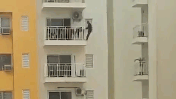 Người đàn ông đu ra ngoài ban công tầng 12 để tập thể dục