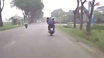 Hai cô gái đổi lái như diễn xiếc trên chiếc xe máy chạy bon bon